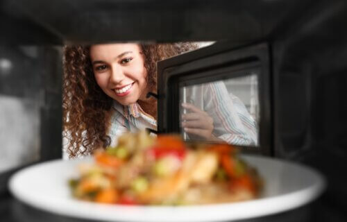 A woman looking into a microwave