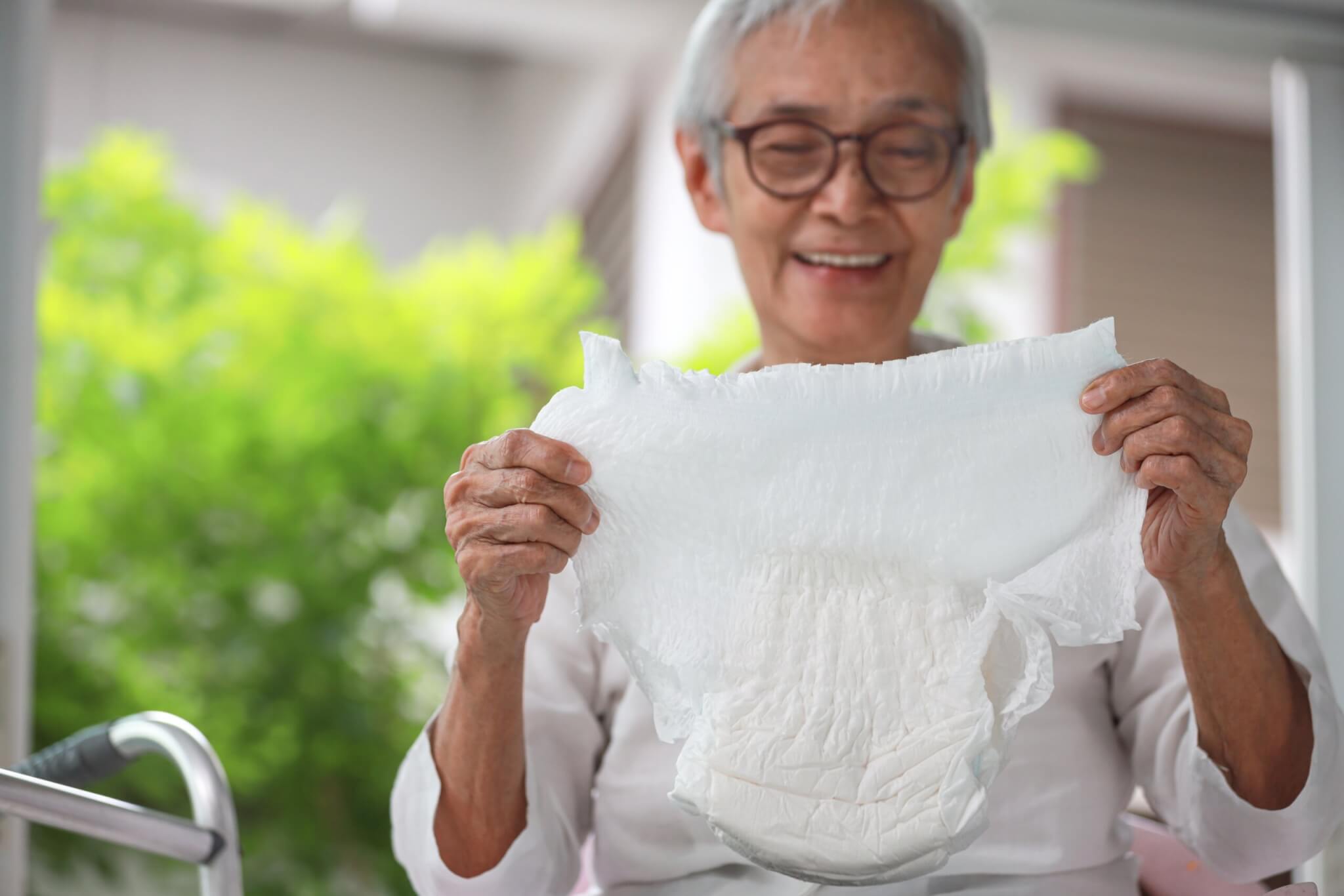 Senior woman holding an adult diaper