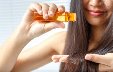 A woman applying hair oil