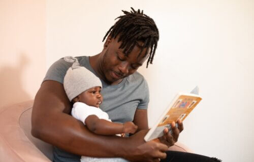 A man reading a book to his baby