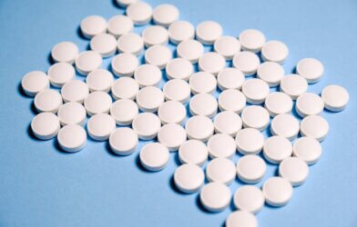 White aspirin Pills on Blue surface