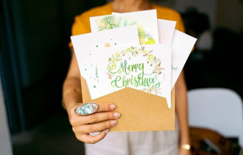 Close-Up Shot of a Person Holding Christmas Cards