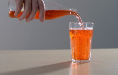 Pouring glass of orange soda