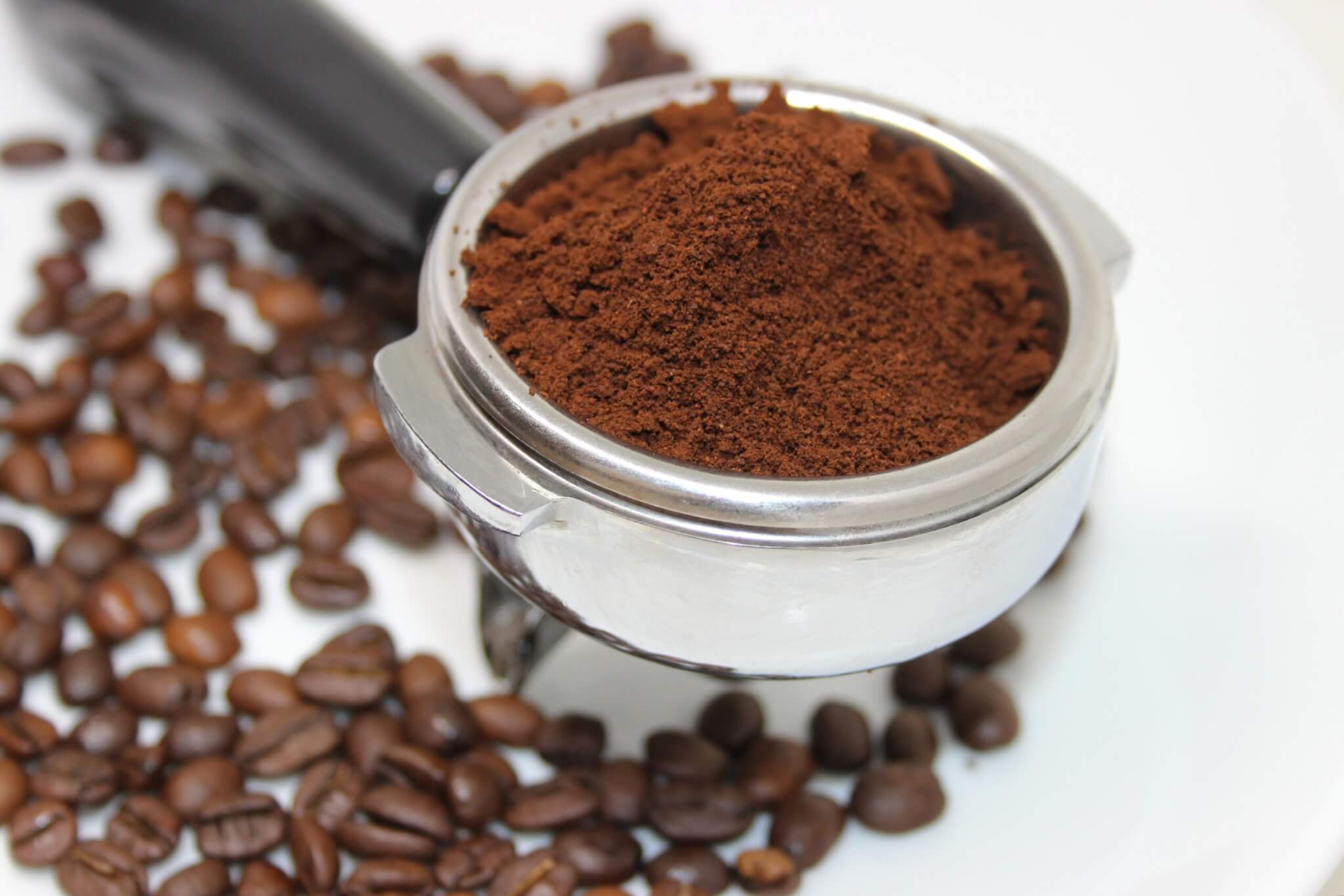 Scoop of coffee grounds and beans