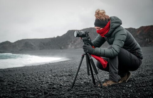 A photographer using a camera tripod