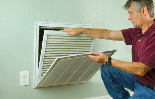 Man replacing home ventilation air filter