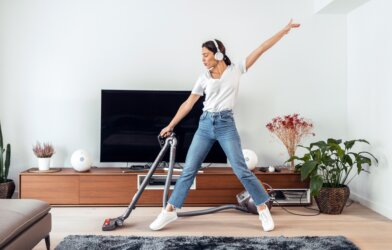 Woman cleaning living room to music