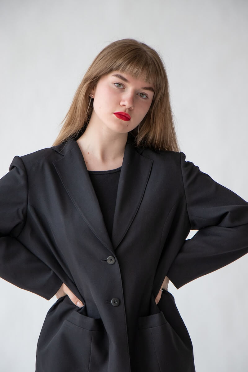 Woman in oversized black blazer standing