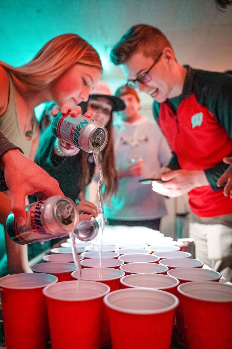 People filling red solo cups with beer