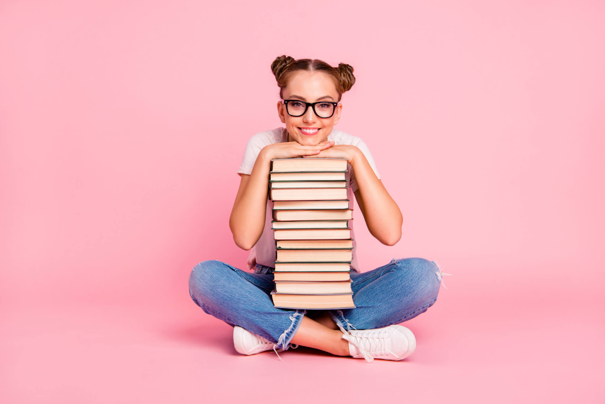 A teenage girl holding a stack of books
