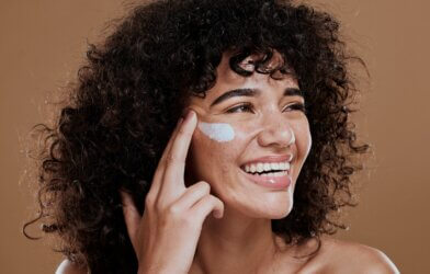 A woman applying face cream