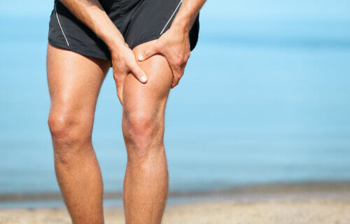 male athlete holding thigh muscle