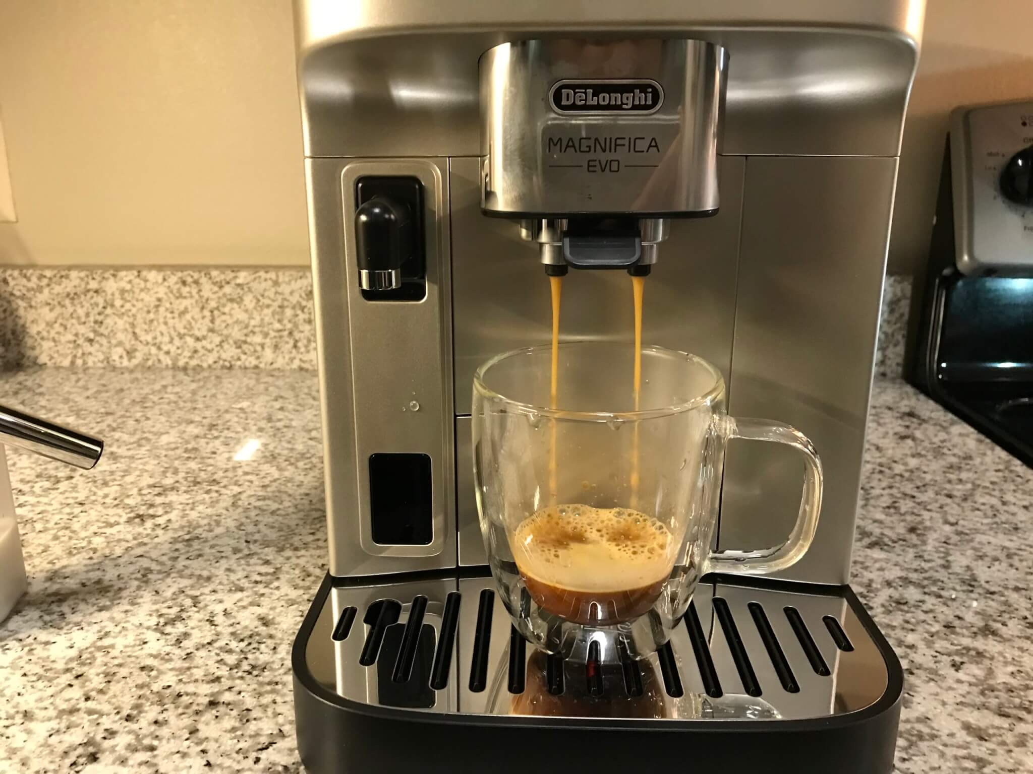De’Longhi Magnifica Evo Espresso Machine brewing a hot cup. 