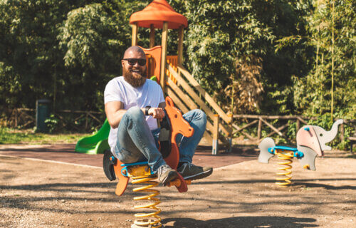 A grown man having fun playing on a playground