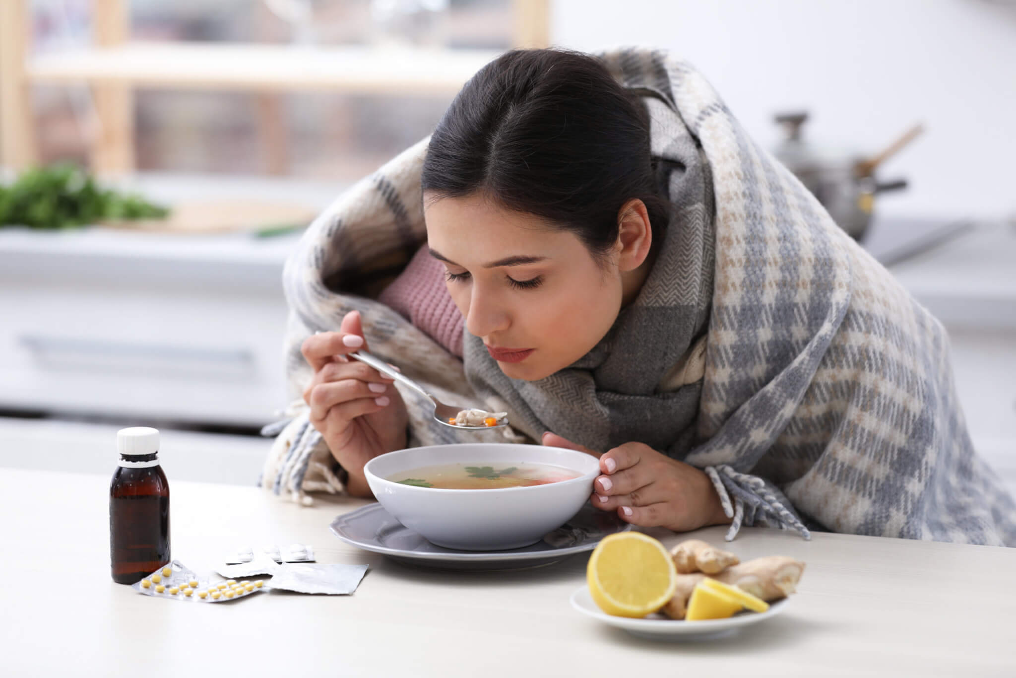 Sick young woman eating soup to cure flu
