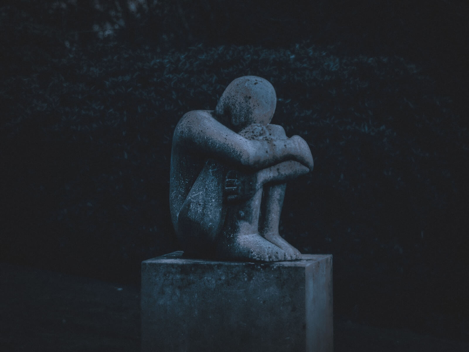 Statue of a man hugging his knees photo by K. Mitch Hodge on Unsplash