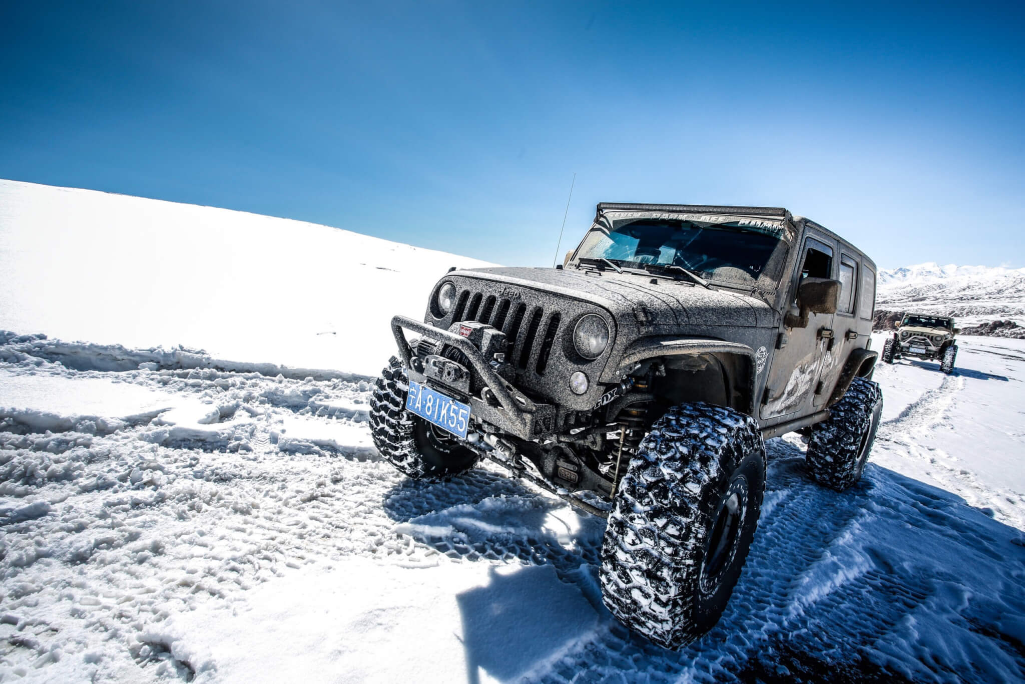 A Jeep Wrangler driving in the snow