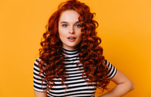 A woman with voluminous red curly hair