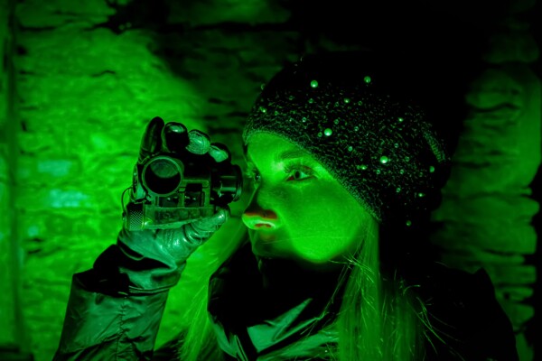A woman looking through a night vision monocular