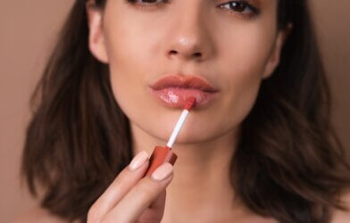 A woman applying lip oil