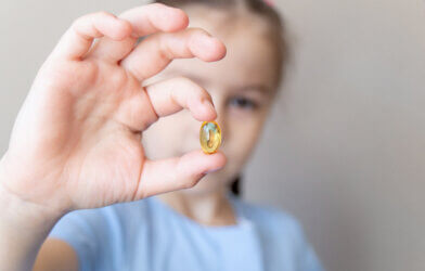 child holding vitamin d supplement