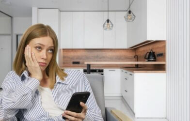 Young bored woman watching smartphone