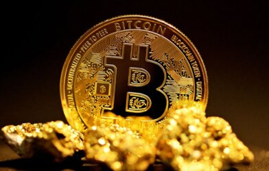 Bitcoin on top of pile of gold