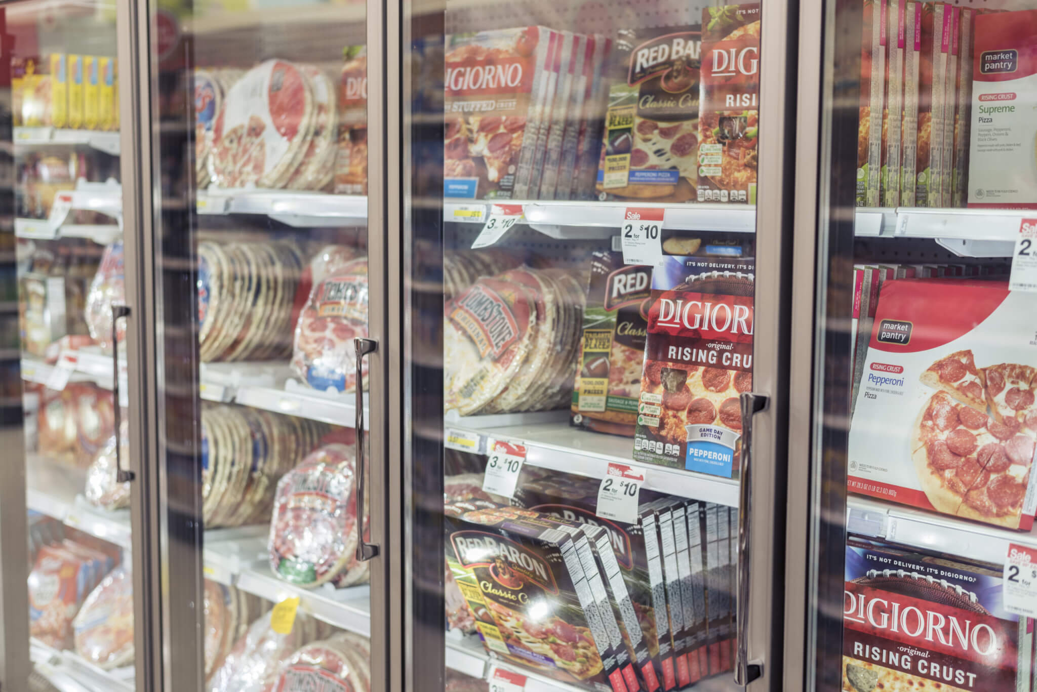 Frozen pizza option in supermarket freezer.