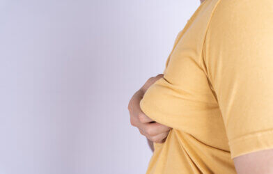 Overweight man holding breast tissue