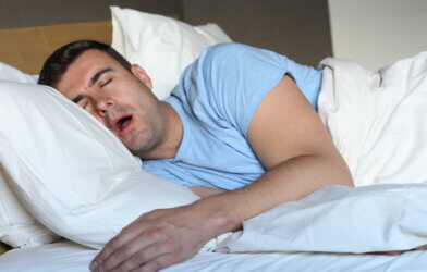 Passed out man drooling in bed breathing from mouth