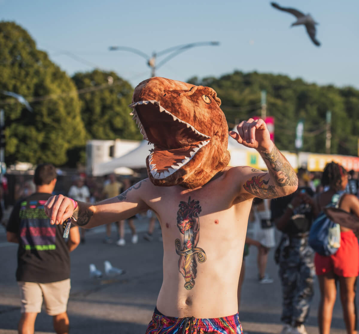 A man with a dinosaur head at Lollapalooza 2019