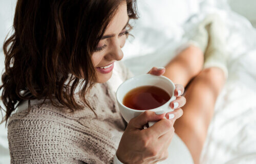 A woman drinking tea in bed