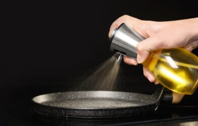 Olive oil cooking spray spraying onto a pan