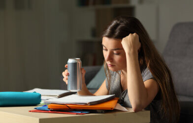Student preparing for exam holding an energy drink