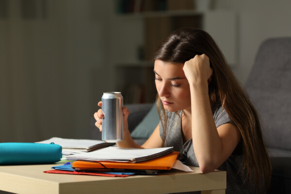 Student preparing for exam holding an energy drink