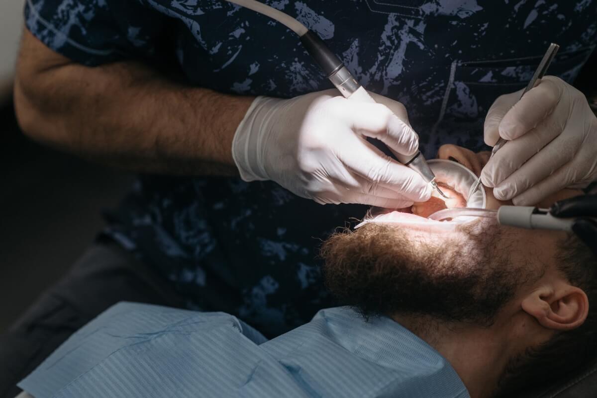 A Person Getting His Teeth Cleaned by a Dentist