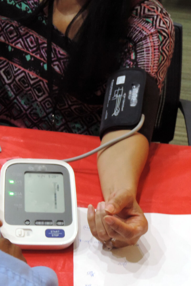A Black woman gets her blood pressure checked