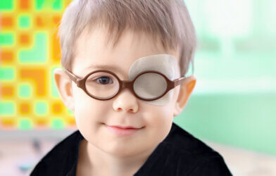 Little boy wearing glasses and an eye patch