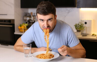 Man eating pasta with bad manners