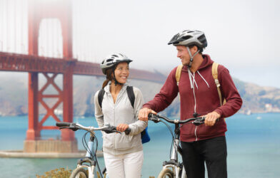 Two people biking by the Golden Gate Bridge in San Francisco