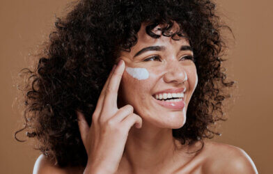 A woman applying face sunscreen