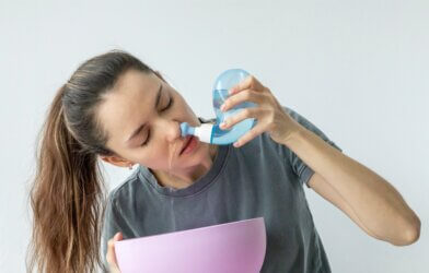 A woman rinsing her nose with a neti pot
