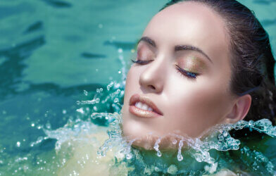 A woman swimming with a full face of makeup
