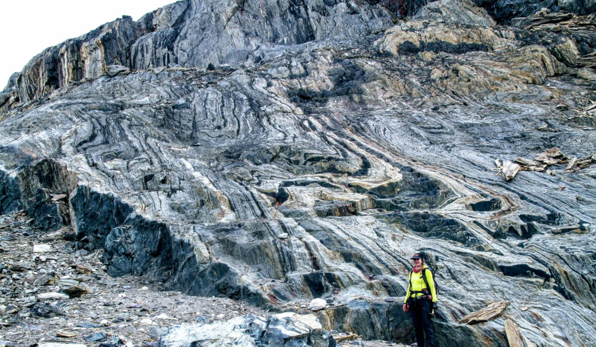 Study co-author Athena Eyster standing in front of a large exposure of banded iron formation, the iron rich deposit from which ancient magnetic field signals were extracted. 