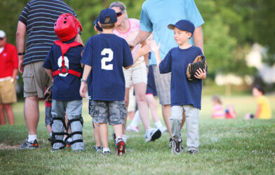 Children high-fiving after little league baseball game