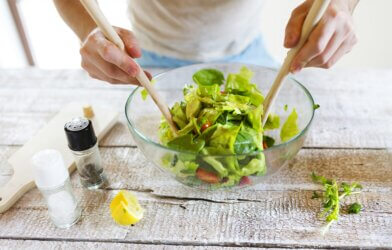 Person making a salad in a bowl