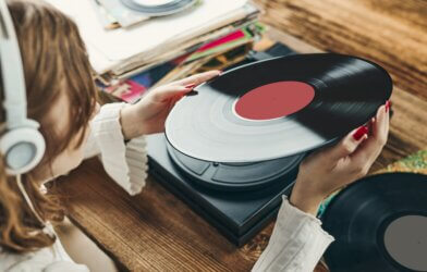 Woman listening to vinyl album on record player