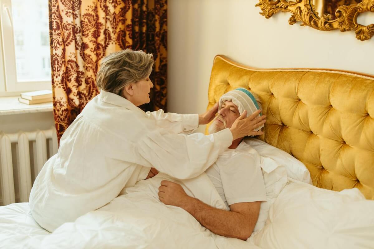 Woman Putting Towel on the Man's Forehead