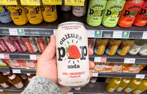 Someone holding a can of Culture Pop probiotic soda in a store