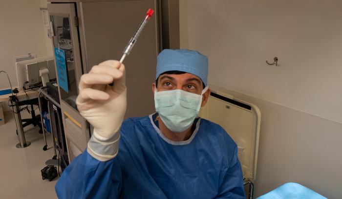 Jason Comander, MD, PhD, director of the Inherited Retinal Disorders Service at Mass Eye and Ear, examines the CRISPR-based medicine prior to performing a surgery of the novel treatment in September 2020, at Mass Eye and Ear in Boston. 